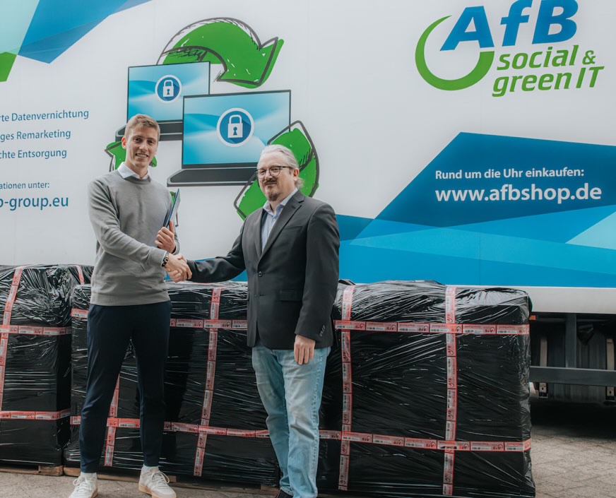 Bild: V. l. n. r. Christian Meißner, Partnermanagement AfB, und Mathias Groben, Director Datacenter firstcolo, vor drei Paletten ausgemusterter Hardware.